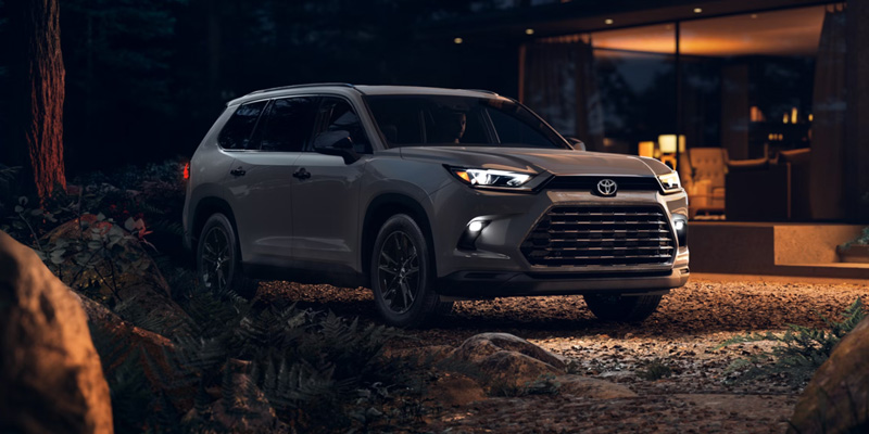 White Toyota Grand Highlander parked at night.